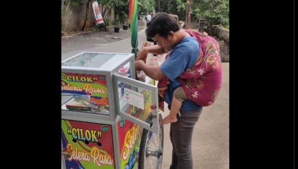 Pedagang Cilok Viral Gendong Anak Saat Berjualan, Banjir Doa dari Netizen