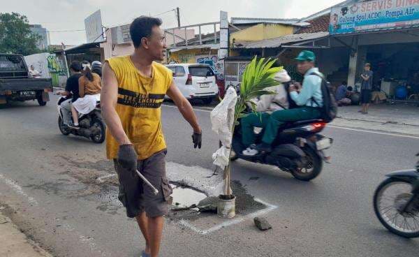 Ngeri! Jalan Rusak di Tangsel Picu Kecelakaan, Warga Pasang Pohon di Tengah Aspal