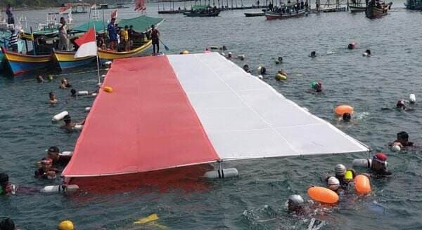 Pecahkan Rekor Dunia, Ratusan Perenang Antar-Pulau Bentangkan Merah Putih di Lautan